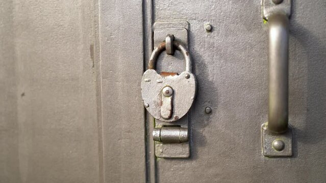 Close up of old metal lock on metal door with handle