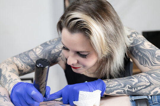 Horizontal photo tattoo artist focused on perfecting her craft. Concept business, art.