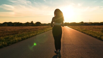 silhouette sports girl running along road sunset, asian female runner jogging road, training...