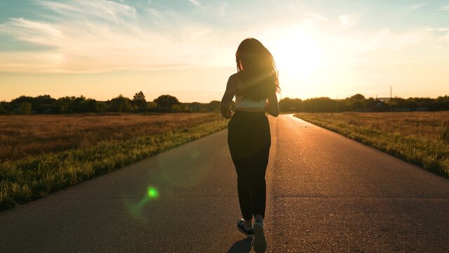 silhouette sports girl running along road sunset, asian female runner jogging road, training running health, sunset running, triathlon, marathon preparation lifestyle, runner man, training hard