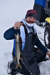 Ice angler with a pike and walleye 