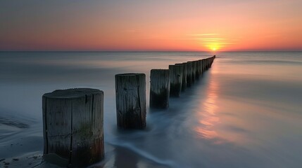 Coastal sunset with weathered wooden breakwaters