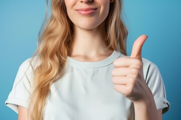 Fototapeta premium woman white t-shirt showing thumb up recommend new advertisement isolated on blue color background