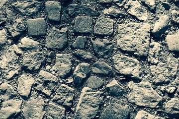 Cobblestone tiles street with big stones, top view. Ancient stone floor. Old pavement for a poster, calendar, post, screensaver, wallpaper, postcard, cover, web. Toned high quality photo