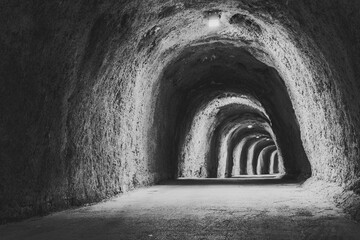 Illuminated Mountain Tunnel. The long tunnel for publication, design, poster, calendar, post, screensaver, wallpaper, postcard, banner, cover, website. Toned high quality photo - obrazy, fototapety, plakaty