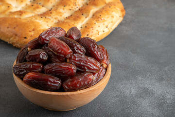 Date fruits and traditional Ramadan pita on black background

