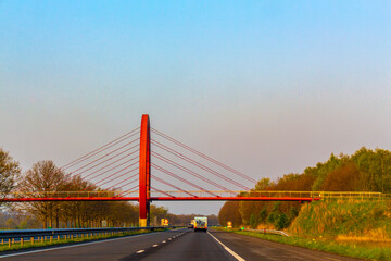 Driving on the highway with bridges between tree avenues Netherlands.