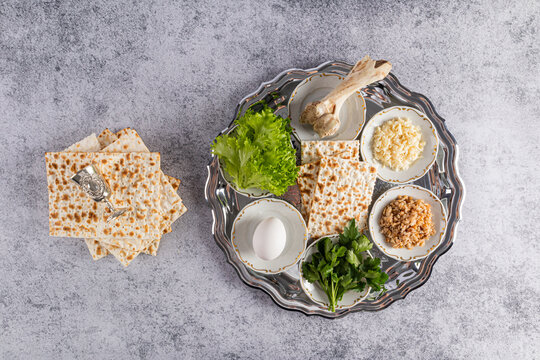 Top view of a silver rich seder tray with traditional treats for the Jewish Passover holiday. Marble background. Passover concept.