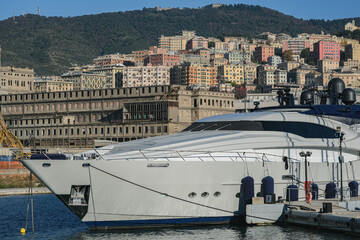 Luxury mega motor yacht in marina in Genoa Genova, Italy harbor port with historic old town...