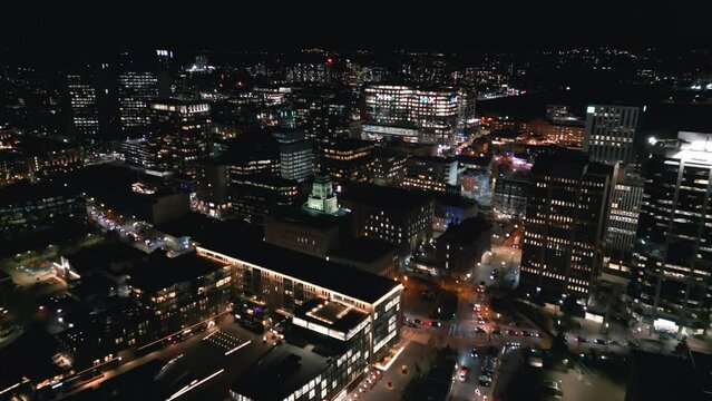 Cinematic drone shot of the Halifax cityscape at night. Aerial view of Halifax entertainment and business districts, city skyline with skyscrapers at night