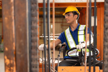Male worker operate folk lift in a factory