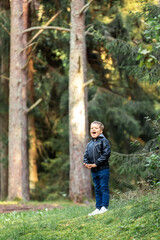 A little boy shouts loudly in the forest and listens to his echo. A mischievous active healthy...