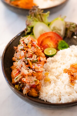A plate of food with a variety of vegetables and meat. The plate is set on a table with a white background