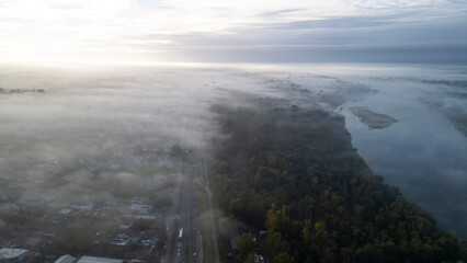 Miasto o wchodzie w mgle z lotu ptaka i rzeką w tle