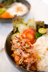 A plate of food with a variety of vegetables and meat. The plate is set on a table with a white background