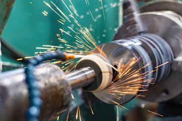 High-precision machining of the metal of the outer surface on a grinding machine with flying sparks and water cooling - obrazy, fototapety, plakaty