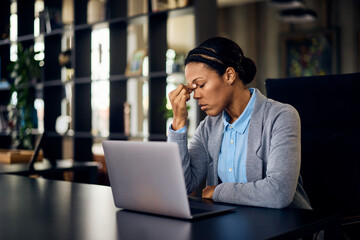 Businesswomen have a headache while working online at the office.