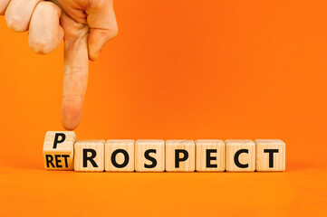 Prospect or retrospect symbol. Concept word Retrospect or Prospect on beautiful wooden cubes. Beautiful orange background. Businessman hand. Business and prospect or retrospect concept. Copy space.