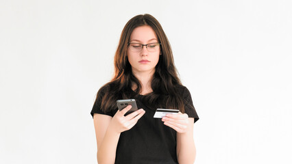 Naklejka premium Bank scam. Transaction risk. Personal data security. Confused woman using phone credit card information for Internet payment isolated on white copy space background.