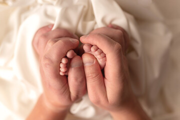 Baby feet of a newborn in dad's hands. On a white background.