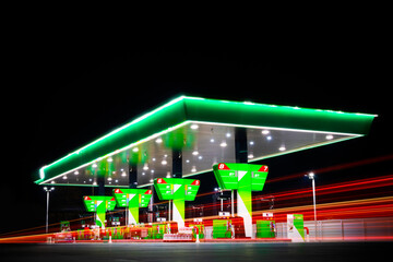green petrol station with red long exposure car light at night - 728006967