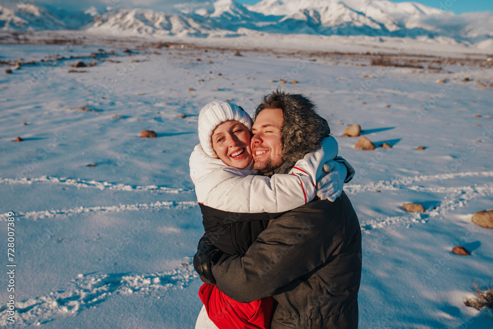 Canvas Prints Romantic young couple embracing on mountains background in winter