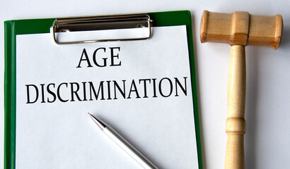 AGE DISCRIMINATION - words on a white sheet on a white background and a judge's gavel