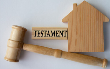 TESTAMENT - word on a wooden block on the background of a house and a referee's gavel