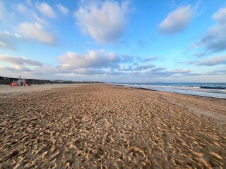 Sandy beach with clouds and sun