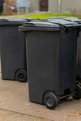 black trash cans on a sidewalk