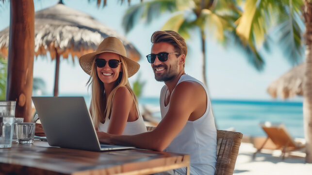 Smiling couple enjoying beach vacation and working , workcation on laptop, relaxation in work and life with embracing happiness by the sea, Travel and work concept.