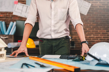 architecture, architect, construction, engineer, project, design, blueprint, house, model, plan. architect or engineer look down on blueprint with a pencil, a ruler, and engineering tools at desk.