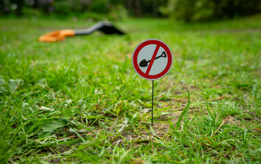 A sign on the lawn forbidding digging.Prohibition of archaeological excavations. A shovel on a...
