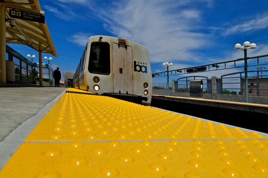 ADA compliant yellow  &ldquo;truncated domes&rdquo; provide detectable warning surface to define the edge of platform and BART train right of way 