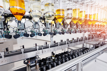 Process Perfume oil bottling on automated production line. Modern manufacturing conveyor for aroma...