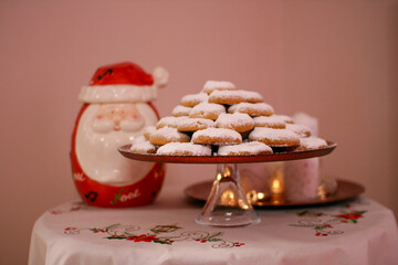 Delicious christmas cookies on a plate with powdered sugar, on a wooden table
