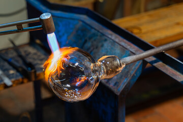 The process of glass making. Creating glass art with hot torch and glassblowing pipe. Glassblower...