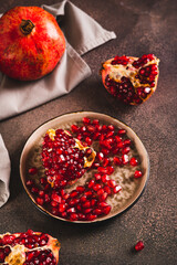 Fresh tasty pomegranate divided into pieces on a plate on the table vertical view