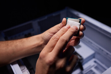 Cropped image of an engineer showing a computer microchip on the foreground