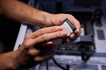 Cropped image of an engineer showing a computer microchip on the foreground