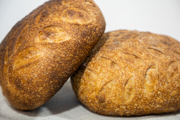 Baked bread. Bread on a table. Two loaves of bread with an ornament. Pattern on bread. Homemade bread. Crisp bread crust. Sourdough bread. Unleavened bread. Yeast-free bread. Bread baked at home.