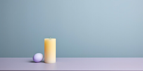 Obraz na płótnie Canvas Creamy candle beside a pastel purple sphere on a clean surface, modern minimalist composition.
