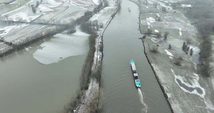 aerial footage of a cargo ship on  a river in winter landscape