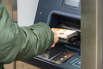 Geld wird dem Bankautomaten entnommen - obrazy, fototapety, plakaty
