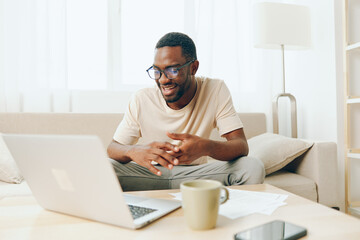 Smiling African American Man Working on Laptop in Modern Home Office, Typing and Enjoying Freelance Lifestyle