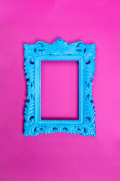 Blue painted baroque frame on magenta background, close up