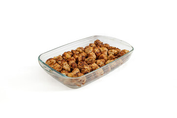Brown oven air fried meatballs in a glass tray, isolated on white