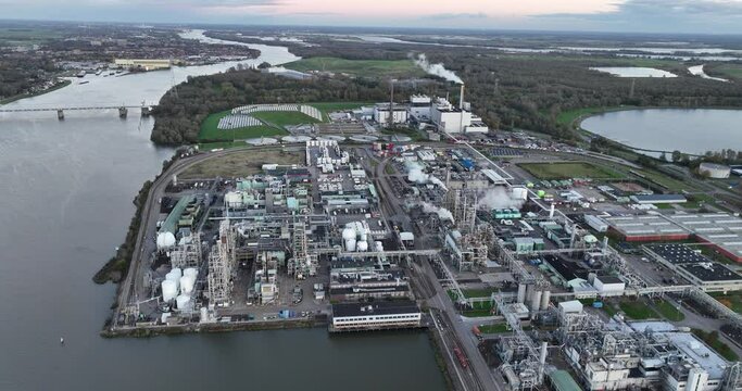 Factory specializing in synthetic polymers and plastics, birds eye aerial drone view in Dordrecht, The Netherlands. Dusk.