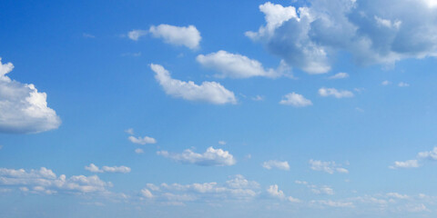 The sky is bright and blue, dotted with numerous white clouds.