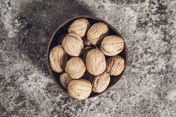 A bowl with whole walnuts in shells. Fresh organic nuts. Overhead view.
